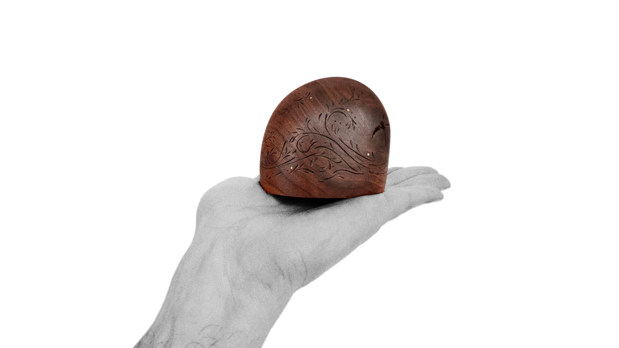 Half domed polished black walnut sculpture about 10 cm heigh with carved decorative pattern held in open hand