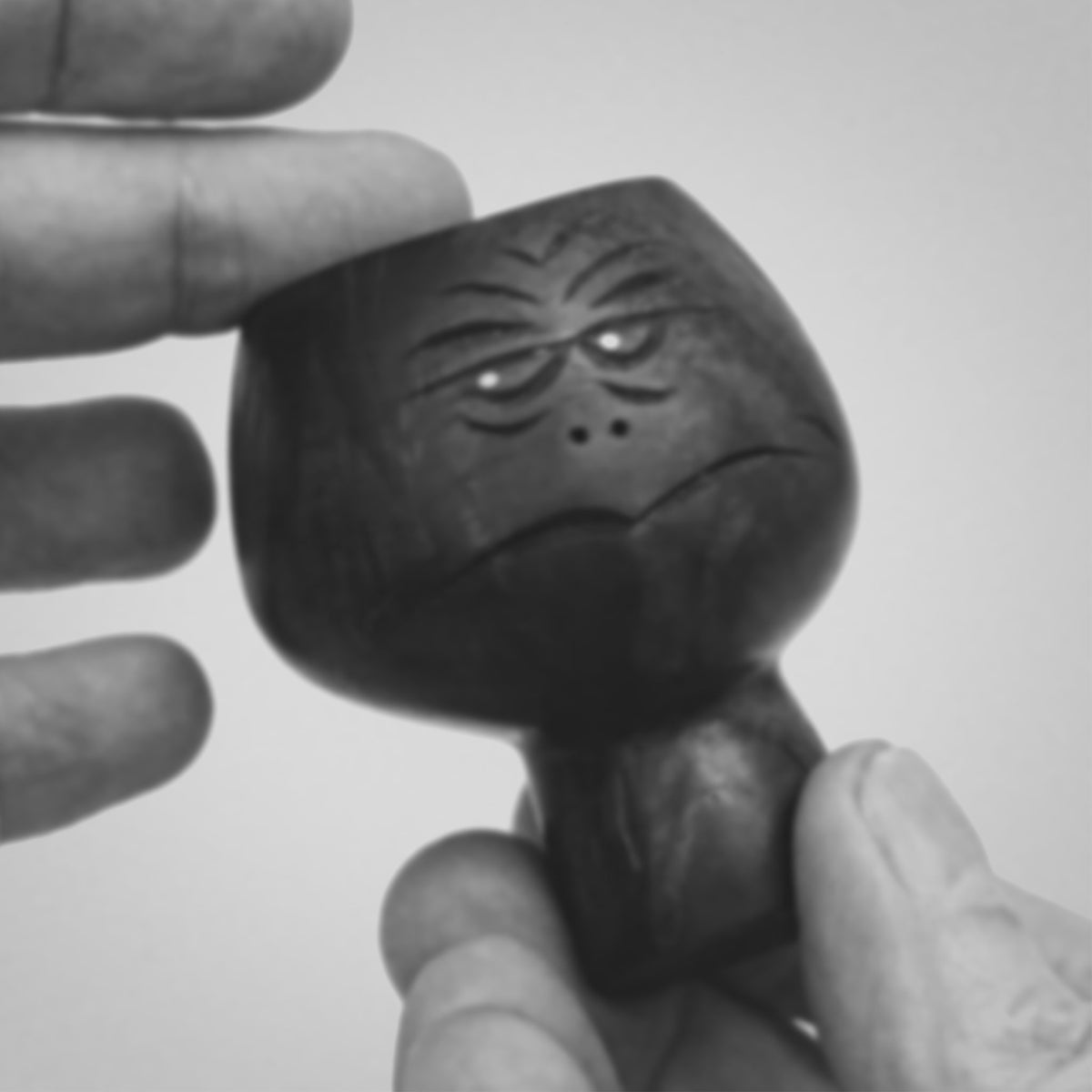 1:1 Black and white video clip of hands showing black walnut wood sculpture of abstracted head figure mid-century style about 8cm high