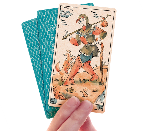 Hand holding 3 cards of the Tarot of Musterberg the Fool card facing the viewer.