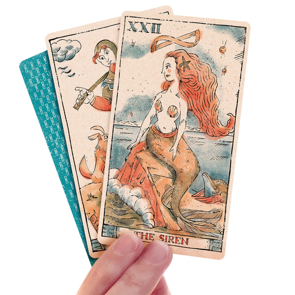 three Tarot of Musterberg cards held by woman's hand back of cards and Fool and Siren cards facing up.