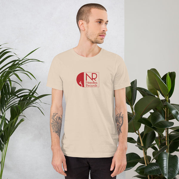 Young man looking to the right wearing cream t-shirt with Needle Records logo