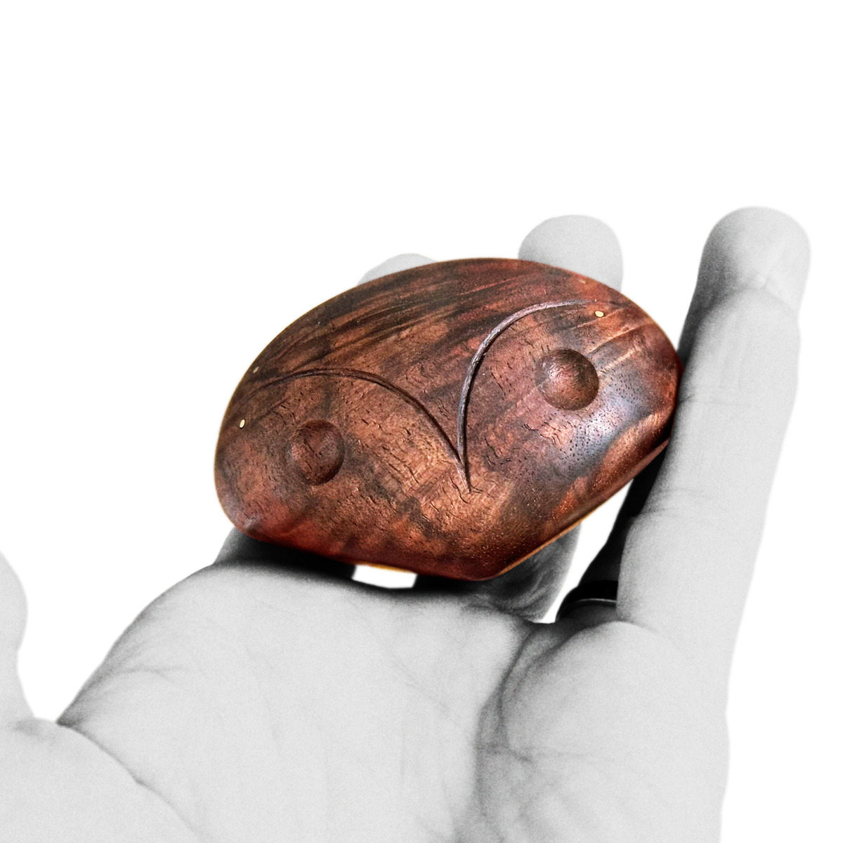 Hand holding black walnut chocolate brown mid-century design style of abstract head figure with brass inlay about 8 cm width